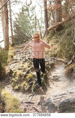 Active Sporty Woman Running In Autumn Fall Forest Jumping Over The Roots On The Path. Healthy Lifest