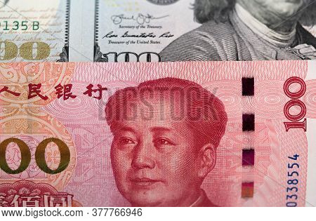 One Hundred Dollars And One Hundred Chinese Renminbi Rmb Bills. Cny Background. Closeup Of Benjamin 