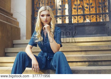 Fashionable Photo Of A Girl, Jumpsuit. Fashionable Style. The Blonde Looks Into The Camera With A Co