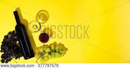 Two Glasses Of Red And White Wine, A Bottle, Grapes On A Yellow Background. The Concept Of Italian W