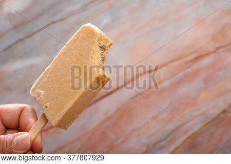 Hand Holding A Fresh Tapioca Milk Tea Flavor Popsicle With A Bite
