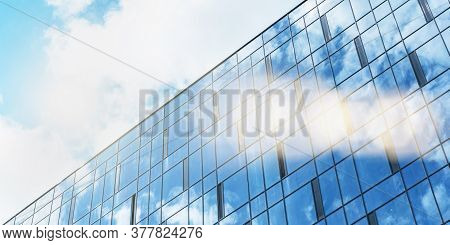 Local City Building With White Clouds Reflections On Large Panoramic Windows Under Bright Summer Sun