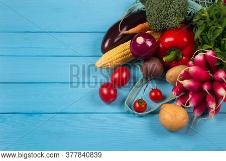 Close Up Of Cotton Bag Full Of Fresh Farm Raw Vegetables From Local Farmer Market, On Blue Wooden Ba
