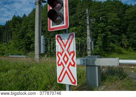 Level Crossing Sign With St. Andrew's Cross And Traffic Lights At A Railway Crossing