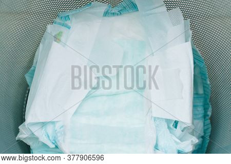 Disposing Of Used Nappies In Trash. Concept Of Child Care. Pollution Of Environment