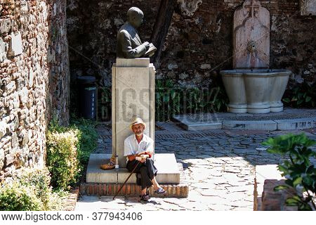 Malaga, Spain - September 03, 2015: A Man Sitting By A Monument In City Center Main Square Of Malaga