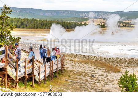 Wyoming, Usa - Aug. 24, 2019: Tourists Visit An Erupting Clepsydra Geyser In The Lower Geyser Basin 