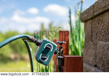 Garden Water Timer On A Spigot With A Splitter And Hoses.