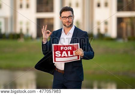 Handsome Real Estate Agent Holding Banner House For Sale. House With Land And Insurance. Business Ma