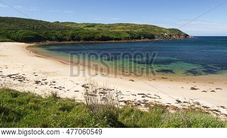 A Sandy Beach Next To A Body Of Water On Broughton Island In Australia