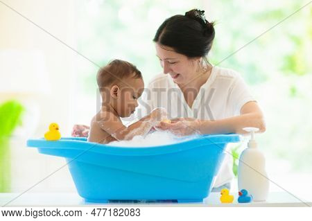 Baby Boy In Bath. Mother Washing Infant Child. Cute Little Toddler Playing With Soap Foam In White S
