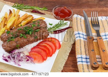 Serving Of The Baked Lula Kebab With French Fries, Chopped Vegetables And Sauce On The White Square 