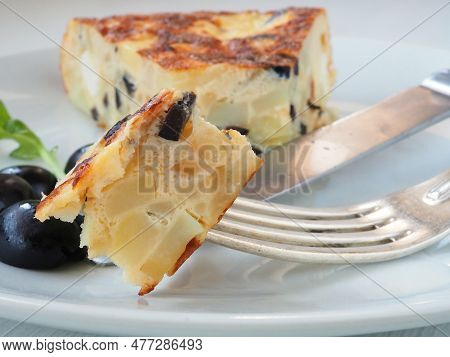 Close-up Of A Tortilla With Black Olives And Feta Cheese On A Fork. Delicious Structure Of Spanish T