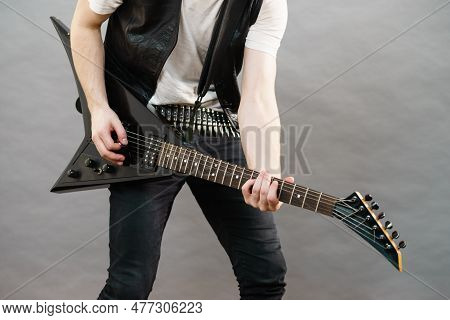 Unrecognizable Hardcore Man Wearing Metal Outfit Playing On Electric Guitar Heavy Rock Music.