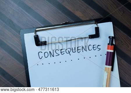 Concept Of Consequences Write On Paperwork Isolated On Wooden Table.