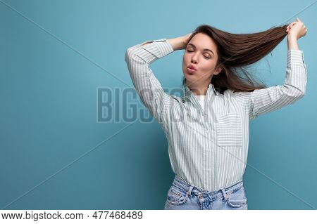 Young Brunette Woman In Shirt With Healthy Silk Hair On Studio Background