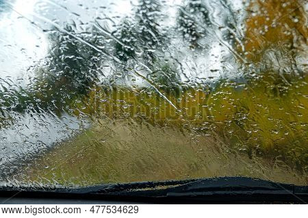 A View Of A Rainy Windshield From The Inside Of A Car Parked On The Side Of The Road, In The Country