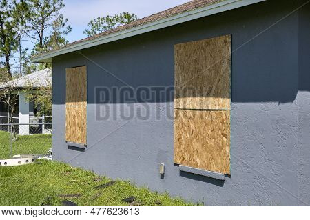 Boarded Up Windows With Plywood Storm Shutters For Hurricane Protection Of Residential House. Protec