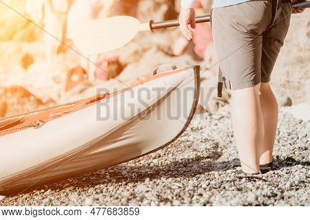 Happy Couple Kayaks In An Inflatable Kayak On The Sea At Sunset. Couple Kanoeing In The Sea Near The