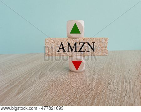 Amzn Price Symbol. A Brick Block With Arrow Symbolizing That Amazon. Com Index Price Are Going Down 