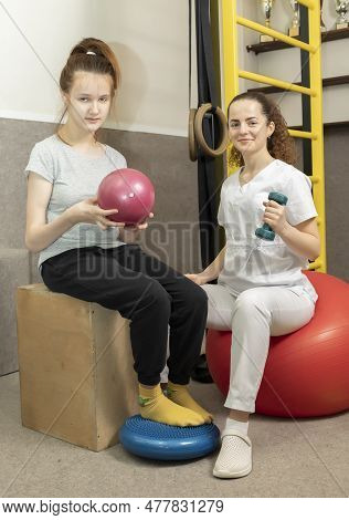 Smiling Child, Child With Disability Does Physical Exercises With Support Of Rehabilitation Speciali