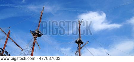 Masts Of An Old Sea Vessel Without Sails Against A Blue Sunny Sky, Copy Space