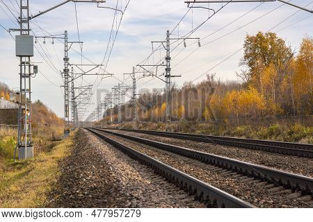 Railroad With Power Supply Pytons In Autumn Season. Travel Landscape