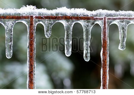 Icicles on a rusted fence after an ice storm.