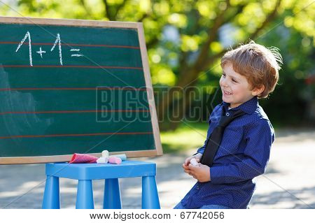 Little Boy At Blackboard Practicing Mathematics