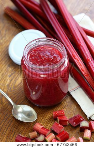 homemade rhubarb jam in jar on wood background
