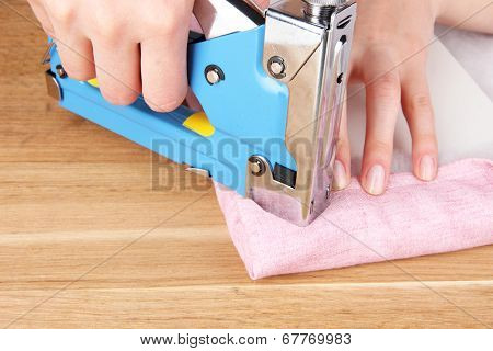 Fastening fabric and board using construction stapler