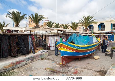 MARSAXLOKK, MALTA - JANUARY 11, 2015: Luzzu, traditional eye boat at Marsaxlokk market, one of the city's main features especially on sunday.