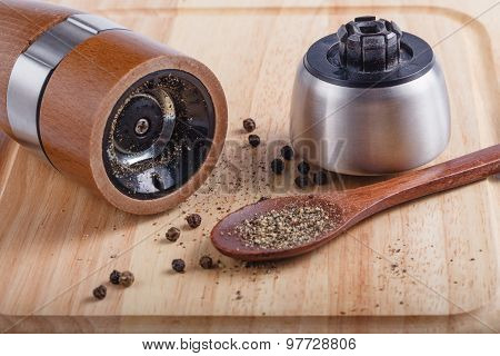 black pepper on the board with a mill