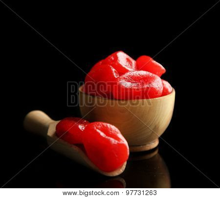 Dried kumquat fruits in wooden bowl, isolated on black