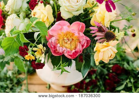 floral design, decoration, applied art, wedding, spring concept - flower bouquet arranged of blooming english roses and avalanches, coral peonies and diathuses, decorated with raspberry leaves