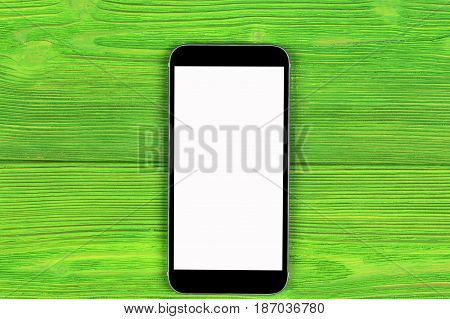 Mobile phone with blank screen mock up isolated on green wood table background. Smartphone on wood table. Smartfone white