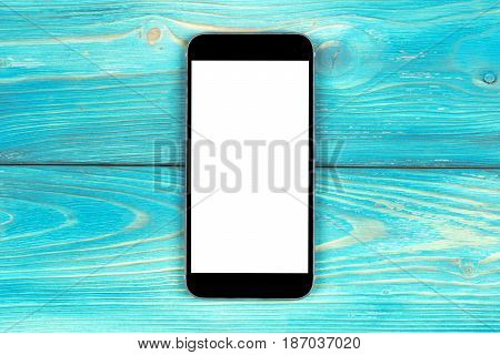 Mobile phone with blank screen mock up isolated on blue wood table background. Smartphone on wood table. Smartfone white