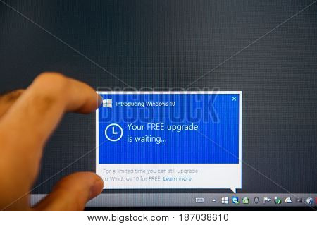PARIS FRANCE - AUG 5 2015: Introducing Windows 10 - Man touching display with message in the dashboard Microsoft recommends to reserve the copy of Windows 10 during the free upgrade period