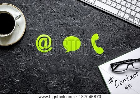 e-mail contact us concept with internet icons and coffee on dark work desk background top view mockup