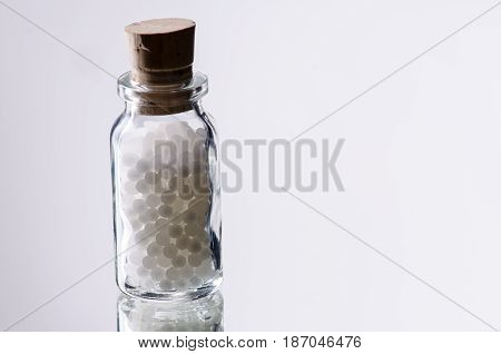 white homepathic globules in a small bottle of glas