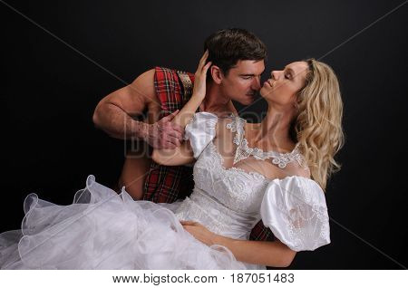 The beautiful couple is in a sexy embrace.