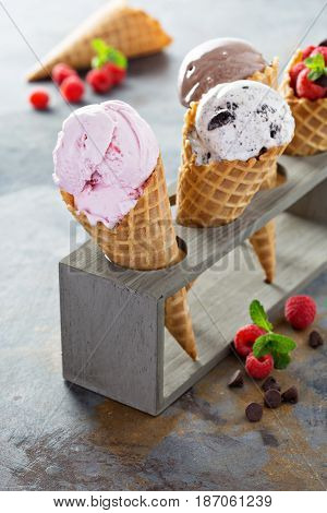 Variety of ice cream scoops in cones with chocolate, vanilla and strawberry