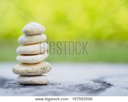 Balance Stones stacked to pyramid in the soft green background to Spa ideas design or freedom and stability concept on rocks.