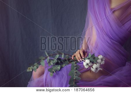 Lovely girl in underwear. Sensual photo. She is in a bikini and a silk scarf. The girl is holding flowers. Man is unrecognizable