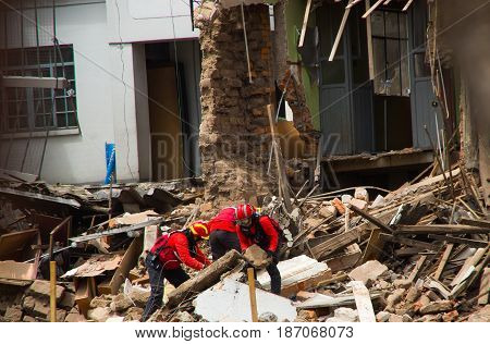 Quito, Ecuador - December 09, 2016: An unidentified group of firemans, cleaning the damage building in Quity Ccity