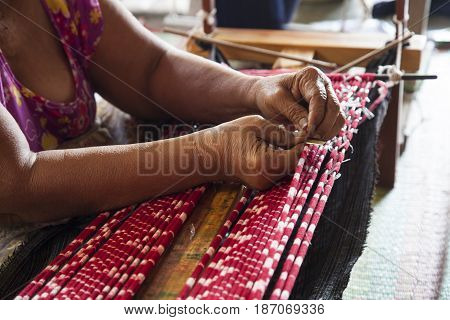 Old asia women demonstrate to procedure of making Thai Silk weaving in small weaving mill