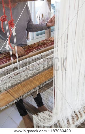 Old asia women demonstrate to procedure of making Thai Silk weaving in small weaving mill