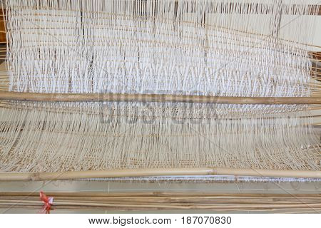 Yarn background old weaving Loom and thread of yarn. A traditional hand-weaving loom being used to make cloth at home.Background surface blurred.