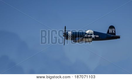 Toy Corsair Military plane flying high in the blue sky