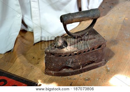 Old cast-iron iron on the floor of the dark loft